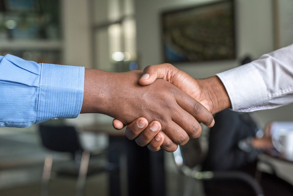 Two people shaking hands after debt settlement.