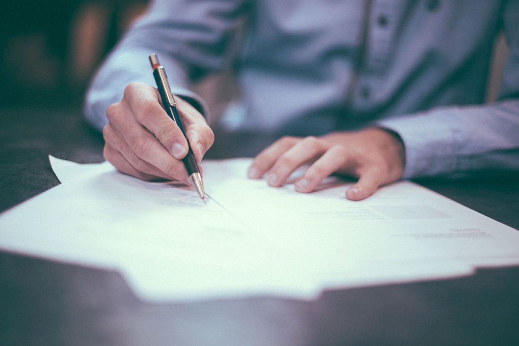 A man writing a debt settlement letter.