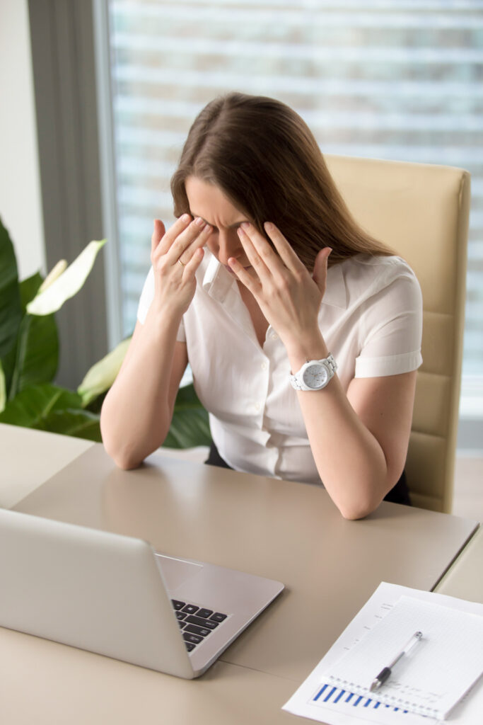 Exhausted woman sitting in front of a laptop